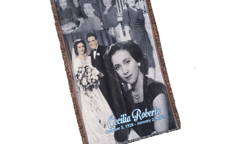 A commemorative blanket features black and white photos of a woman at different life celebrations, including her wedding, with Cecilia Roberts, October 3, 1928 - January 22, 2015 written in blue text.